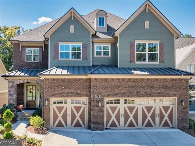 view of front of home featuring a garage, a standing seam roof, and brick siding