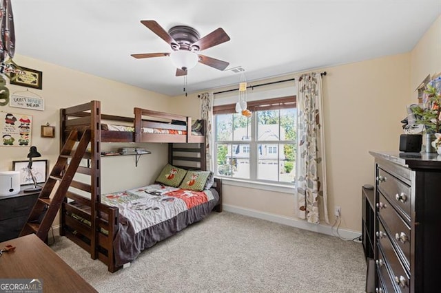 bedroom featuring light colored carpet, ceiling fan, visible vents, and baseboards