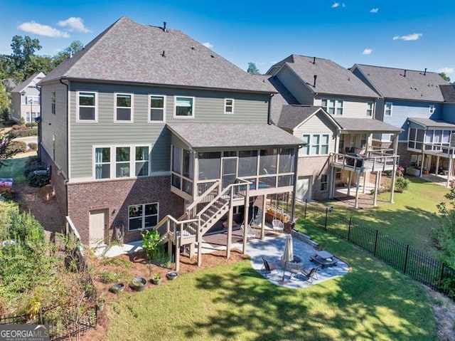 rear view of house with a patio, fence, a sunroom, a lawn, and stairway