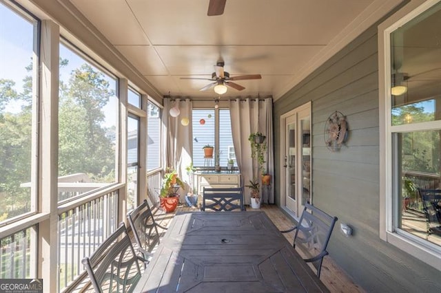 unfurnished sunroom featuring ceiling fan