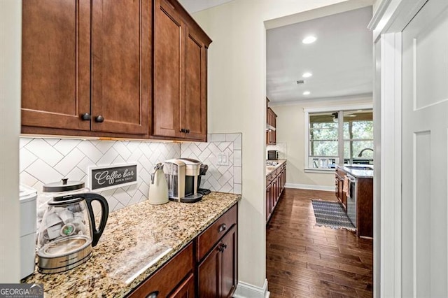 kitchen with light stone counters, dark wood-style flooring, recessed lighting, backsplash, and baseboards