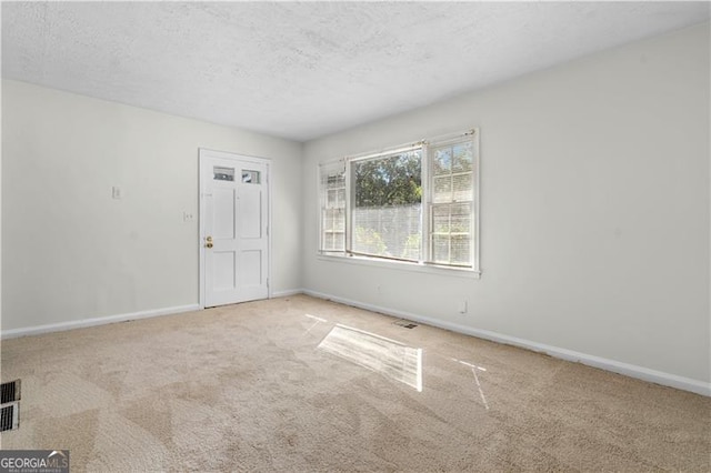 carpeted spare room featuring a textured ceiling