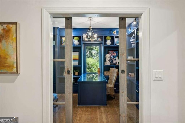 interior space with wood-type flooring and a notable chandelier