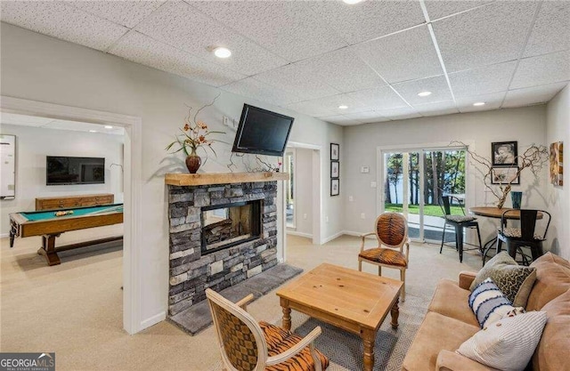 living room with a drop ceiling, light colored carpet, a fireplace, and billiards