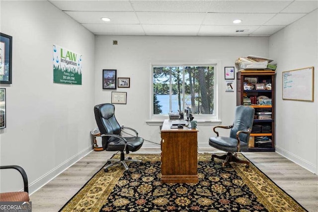 home office featuring light hardwood / wood-style flooring and a drop ceiling