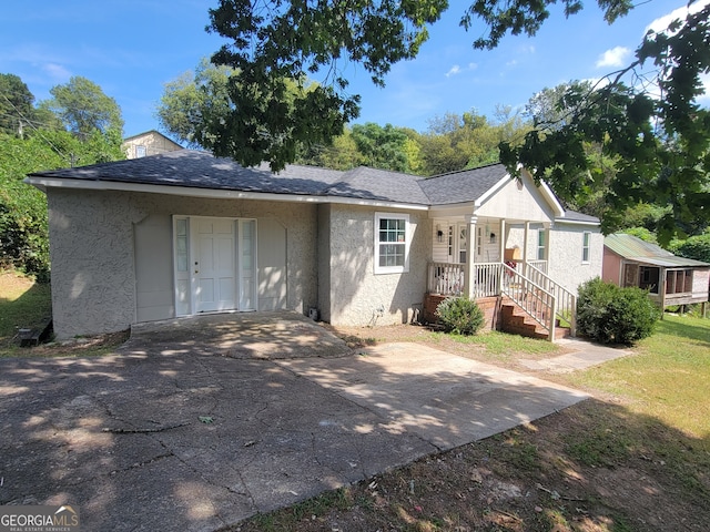 ranch-style home with a porch, a front yard, and a garage