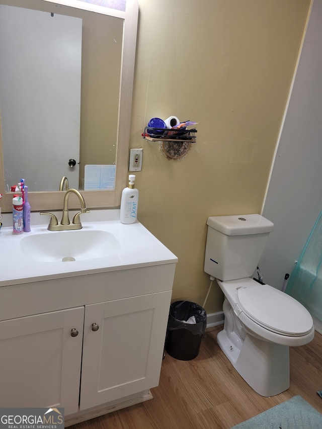 bathroom with vanity, toilet, and wood-type flooring