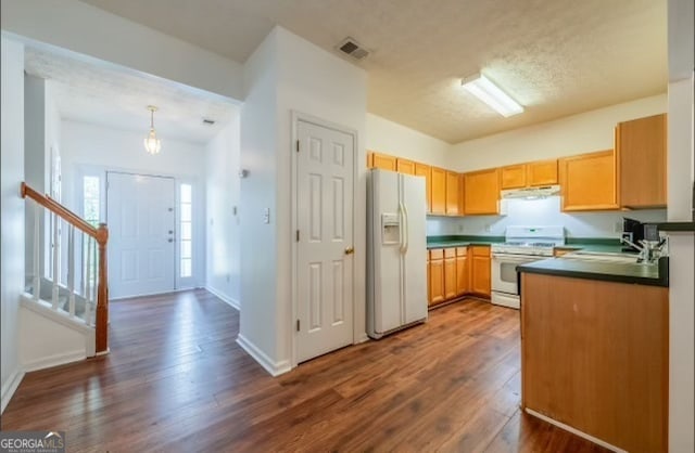 kitchen featuring a textured ceiling, dark hardwood / wood-style floors, sink, decorative light fixtures, and white appliances