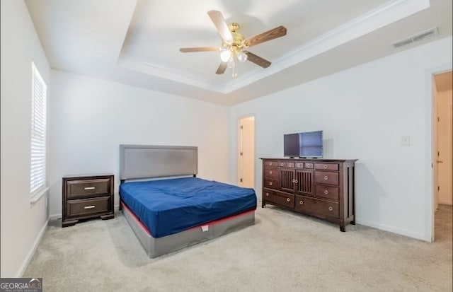 carpeted bedroom featuring crown molding, a raised ceiling, and ceiling fan