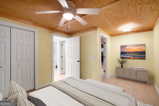 bedroom with wood ceiling, ceiling fan, light tile patterned flooring, and a closet