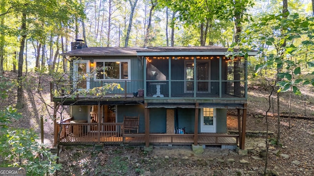 rear view of property featuring a deck and a sunroom