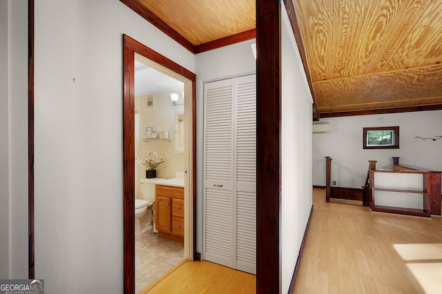 hall with light wood-type flooring, a wall unit AC, and wood ceiling