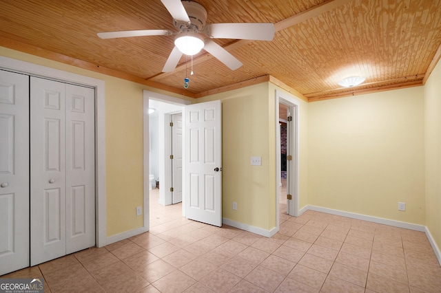 unfurnished bedroom featuring wooden ceiling, a closet, ceiling fan, and light tile patterned flooring