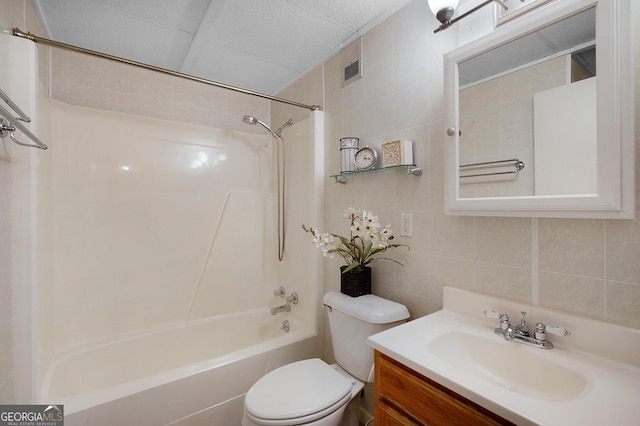 full bathroom with tile walls, vanity, bathing tub / shower combination, and toilet