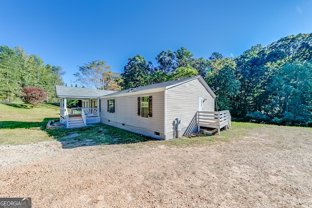 manufactured / mobile home with covered porch and a front lawn