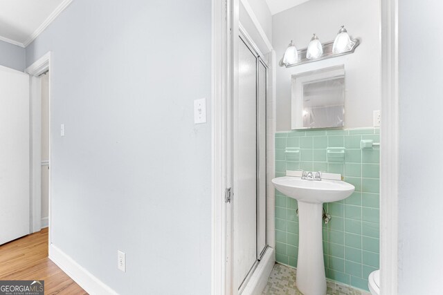 bathroom featuring tile walls, ornamental molding, wood-type flooring, and toilet