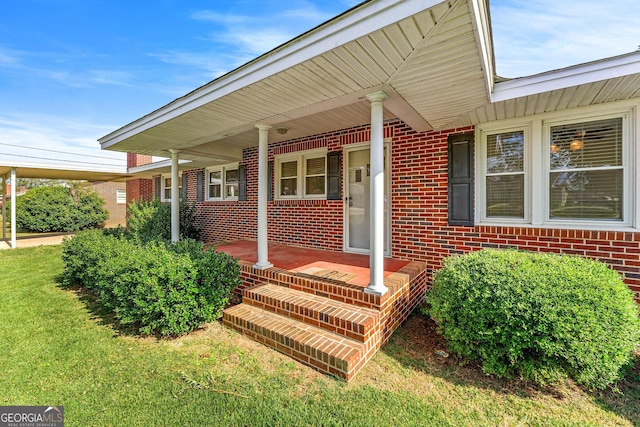 doorway to property featuring covered porch and a yard