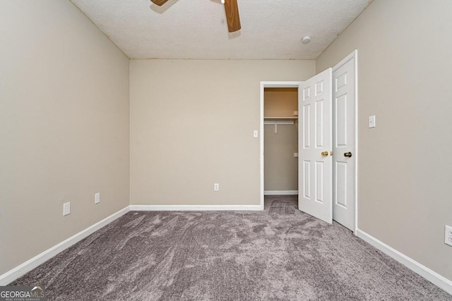 unfurnished bedroom featuring a closet, a textured ceiling, carpet floors, and ceiling fan