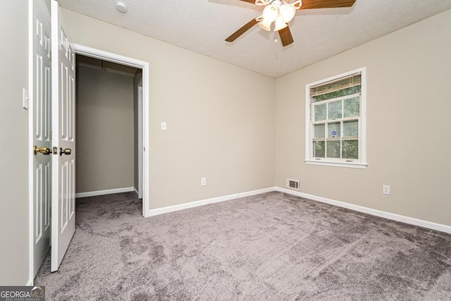 empty room featuring carpet, a textured ceiling, and ceiling fan