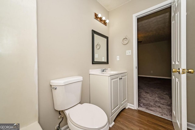 bathroom featuring vanity, toilet, and hardwood / wood-style flooring