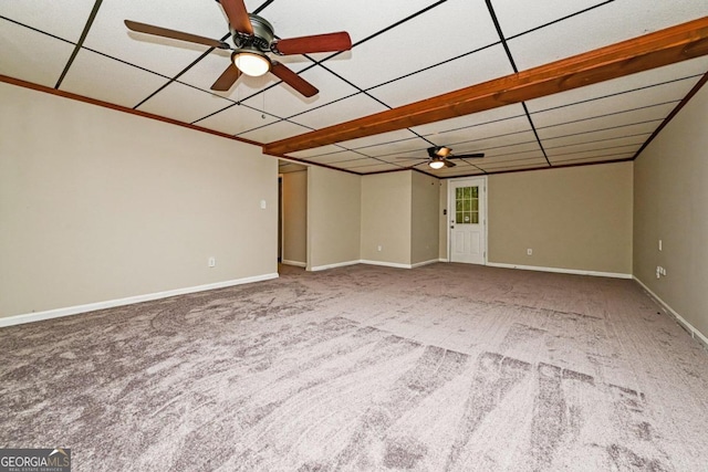 empty room featuring a paneled ceiling, carpet, and ceiling fan