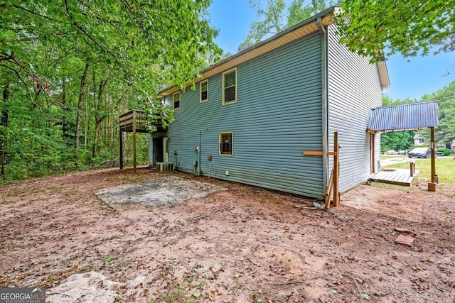 view of home's exterior with central air condition unit and a deck