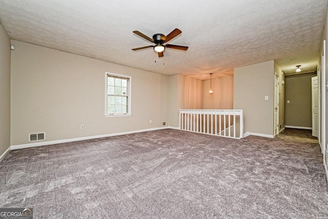 unfurnished room featuring a textured ceiling, carpet flooring, and ceiling fan