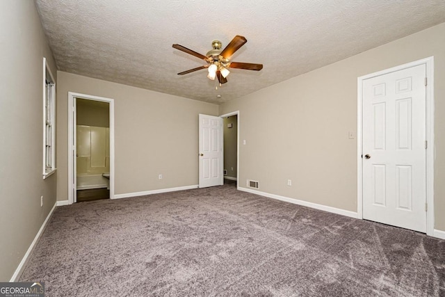 unfurnished bedroom with ensuite bathroom, dark colored carpet, a textured ceiling, and ceiling fan