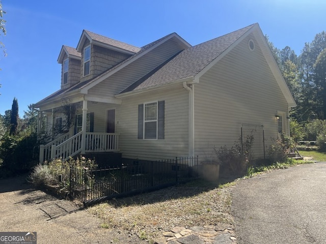 view of side of home with covered porch