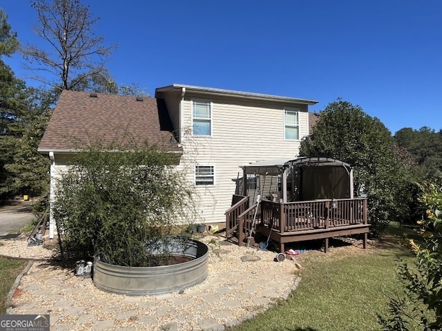 rear view of house featuring a wooden deck