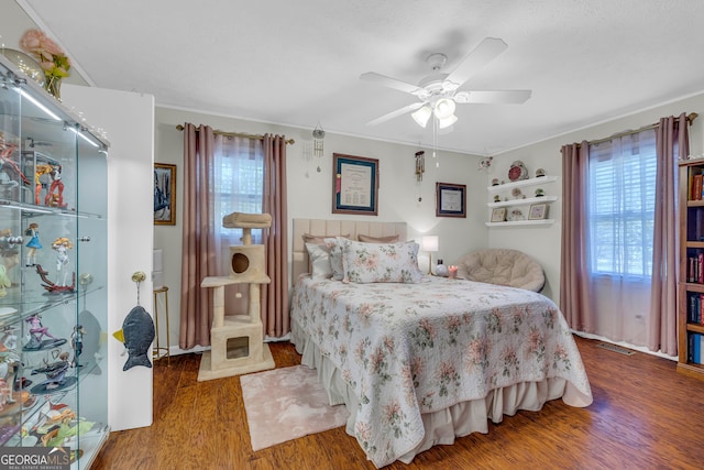 bedroom with hardwood / wood-style floors, crown molding, and ceiling fan