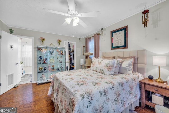 bedroom featuring a walk in closet, a closet, ceiling fan, hardwood / wood-style flooring, and ornamental molding