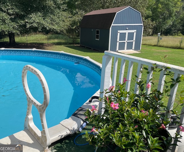 view of pool with a yard and a shed