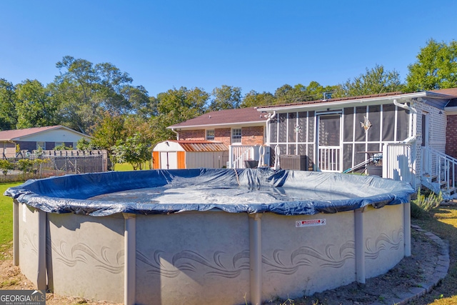 view of pool with a sunroom and a shed