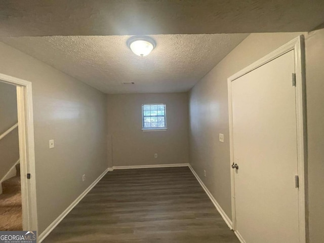 interior space featuring a textured ceiling and dark hardwood / wood-style flooring