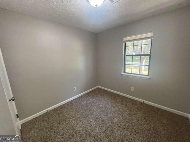 carpeted spare room featuring a textured ceiling