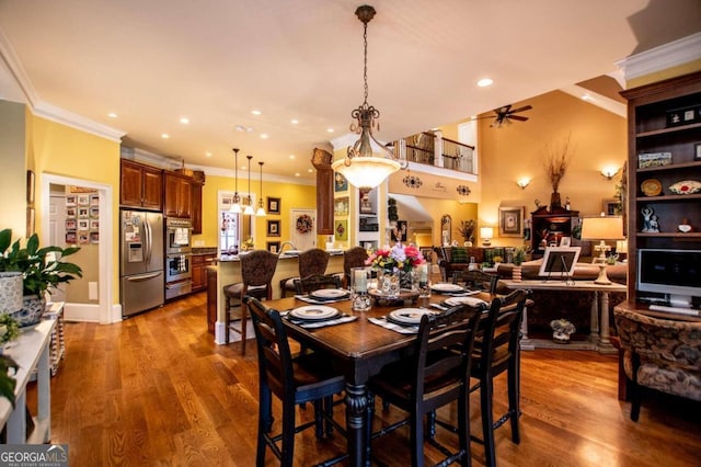 dining space featuring hardwood / wood-style floors, crown molding, and ceiling fan