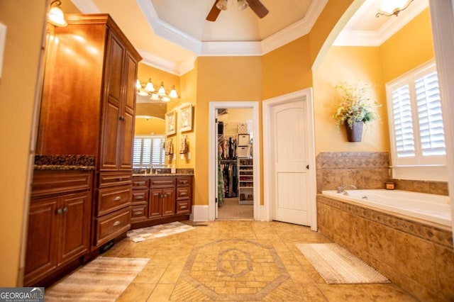 bathroom with vanity, crown molding, tiled bath, and a wealth of natural light