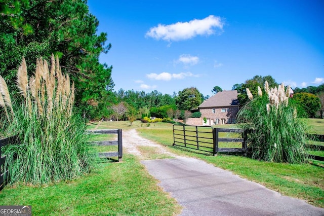 view of gate featuring a yard and a rural view