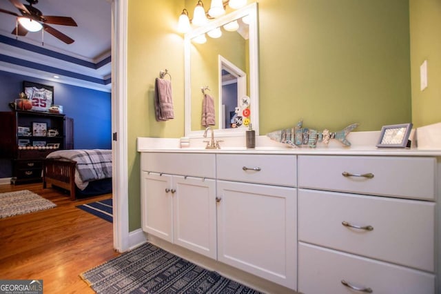 bathroom with vanity, crown molding, wood-type flooring, and ceiling fan