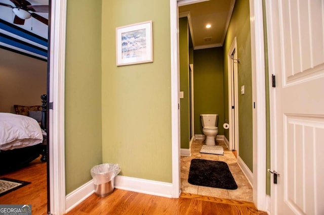 bathroom featuring toilet, hardwood / wood-style floors, and ceiling fan