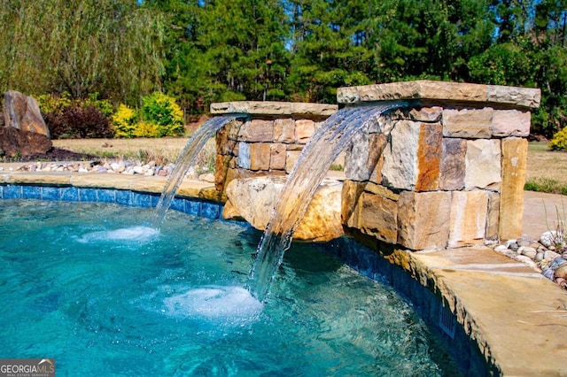 view of swimming pool with pool water feature