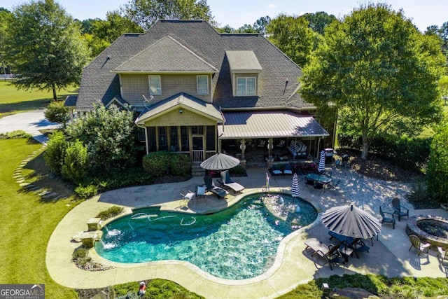 view of swimming pool featuring a patio, an outdoor fire pit, and a yard