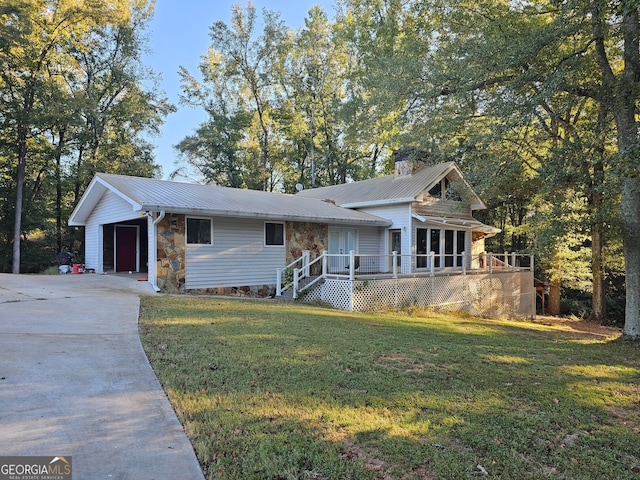 ranch-style house featuring a front yard, a garage, and a deck