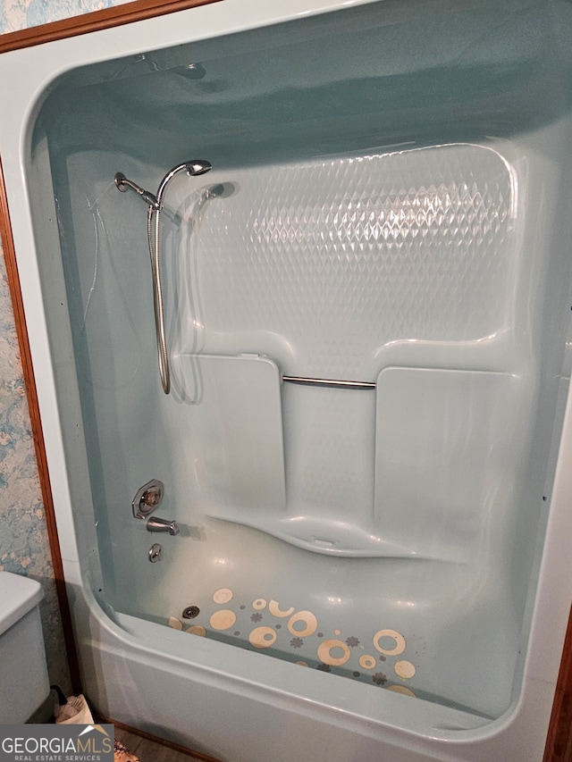 room details featuring toilet and shower / bathtub combination