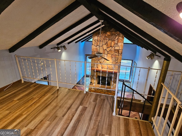 unfurnished living room featuring lofted ceiling with beams and wood-type flooring