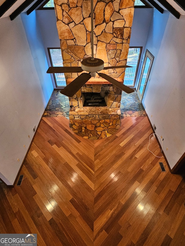 interior details with beam ceiling, hardwood / wood-style flooring, and a fireplace
