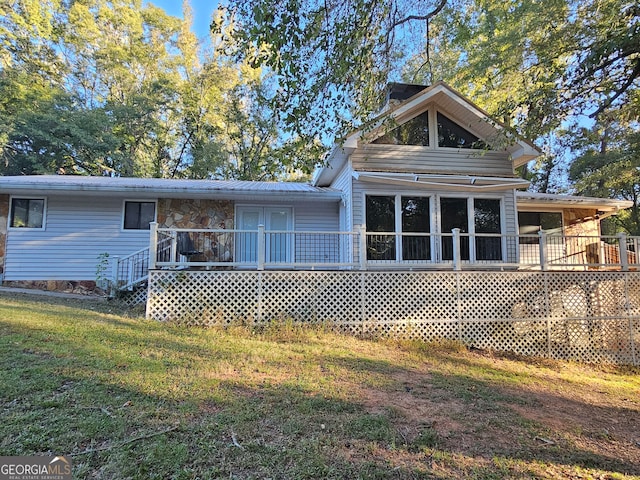 back of house with a deck and a yard