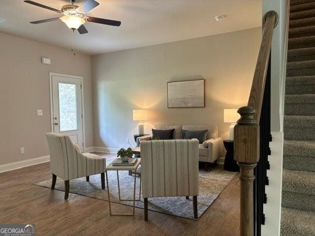 living room featuring wood-type flooring and ceiling fan