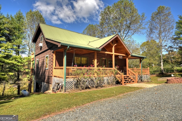 log-style house featuring covered porch and a front yard